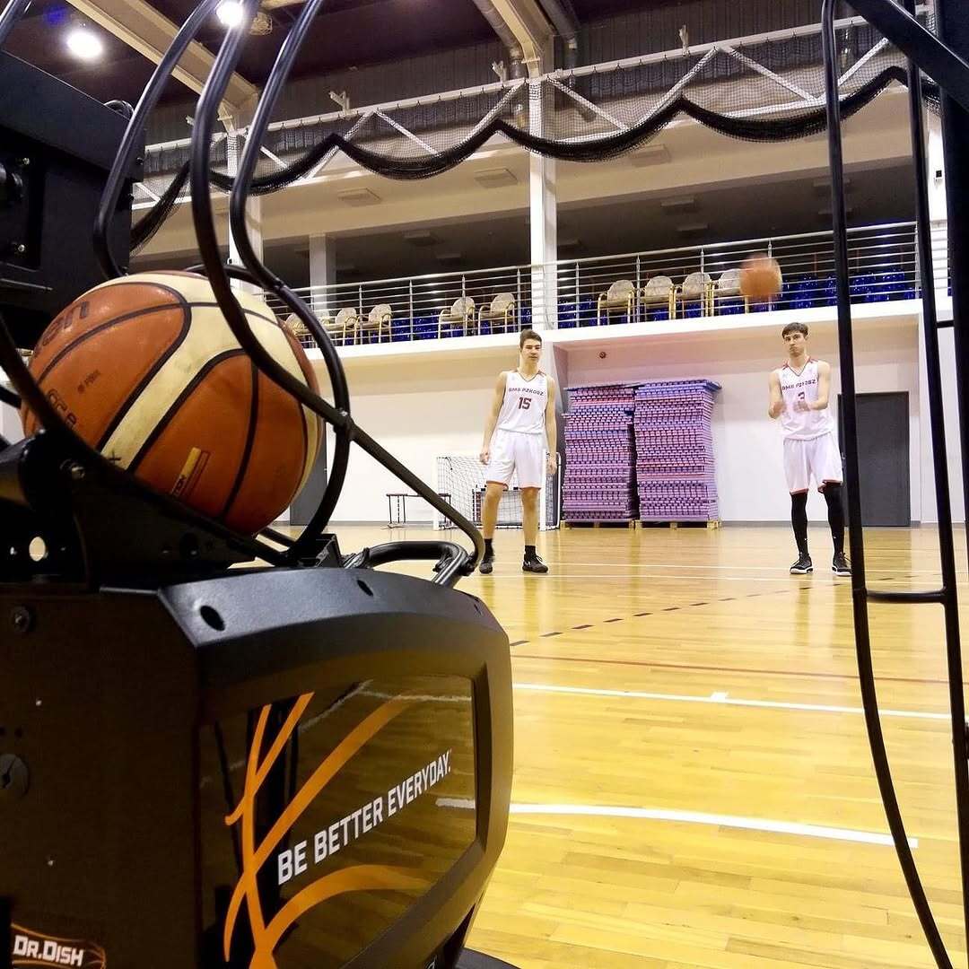 Two players from NLO SMS PZKosz Władysławowo training on a Dr. Dish CT+ basketball shooting machine during a federation-supported development session in Poland.